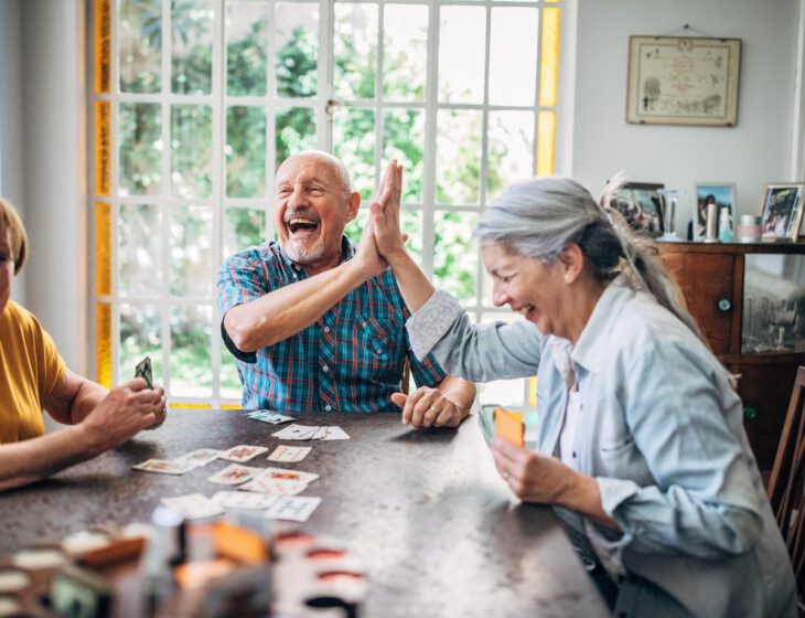 group of seniors enthusiastically enjoying a card game together